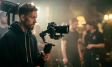 cinematic banner of videographer setting up camera
